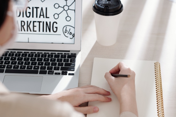 Persona planificando estrategias de marketing digital frente a una laptop, ideal para ilustrar qué es el marketing digital y cómo se organiza una campaña.